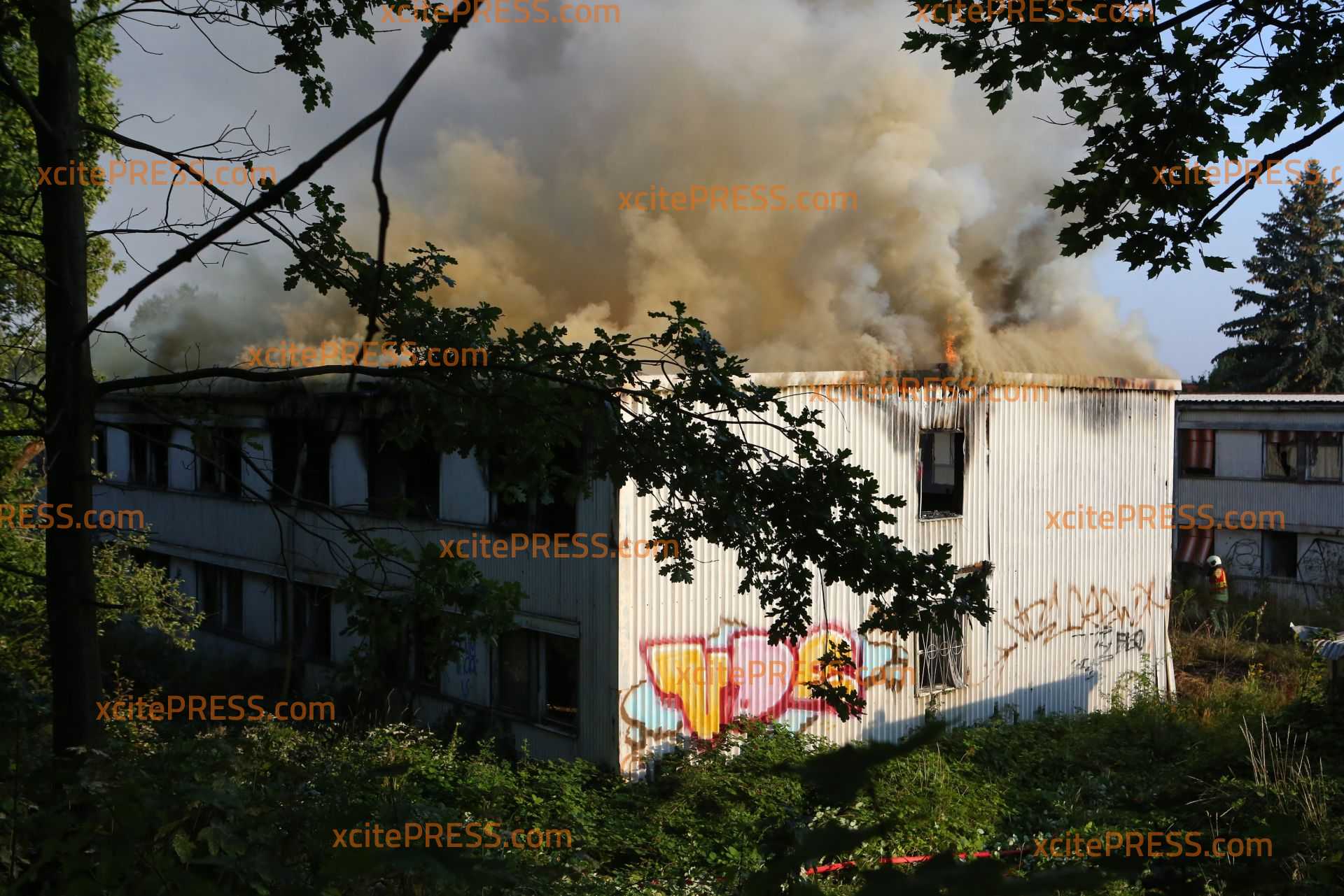 Großeinsatz für Feuerwehren: Leerstehende Baracke brennt in Räcknitz: Dichte Rauchschwaden ziehen Richtung Stadt, Anwohner sollen Fenster und Türen geschlossen halten