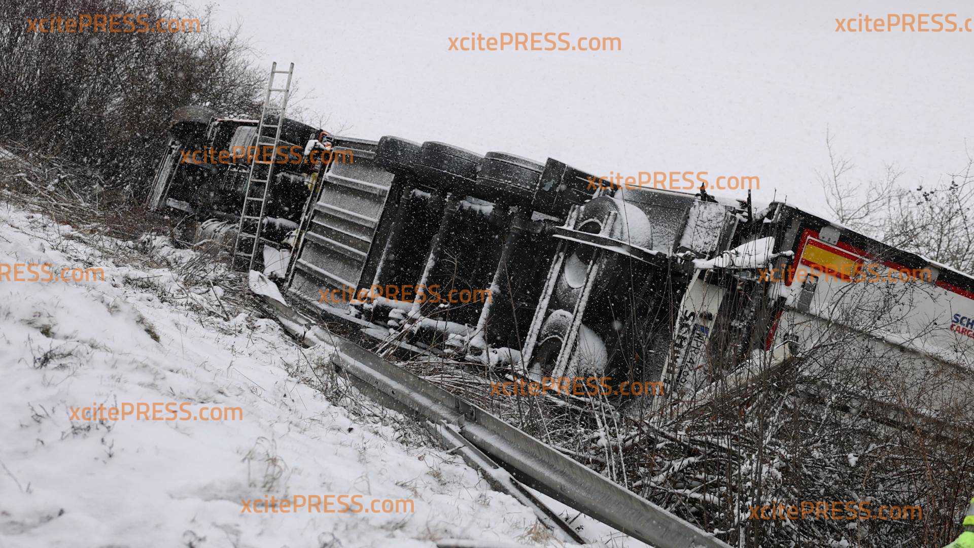 Schnee & Glätte: LKW durchbricht Schutzplanke und landet auf Seite: Fahrer glücklicherweise unverletzt